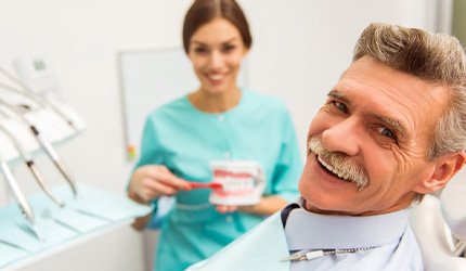 An older man smiling with his dentures