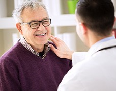 An older man talking to his dentist