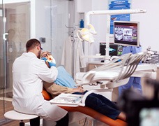 A dentist performing dental work on an older patient