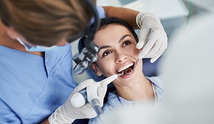 a woman having her teeth cleaned by a dentist
