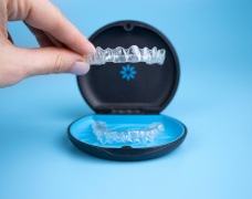 Patient putting clear aligner in case