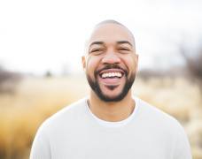 Man in white shirt smiling outside