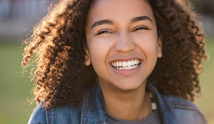 Closeup of teen girl in jean jacket smiling
