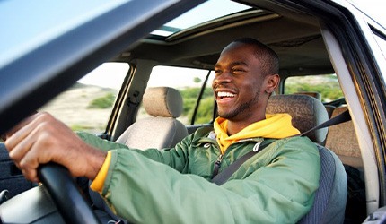 Man smiles as he drives