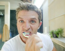 Man brushes teeth