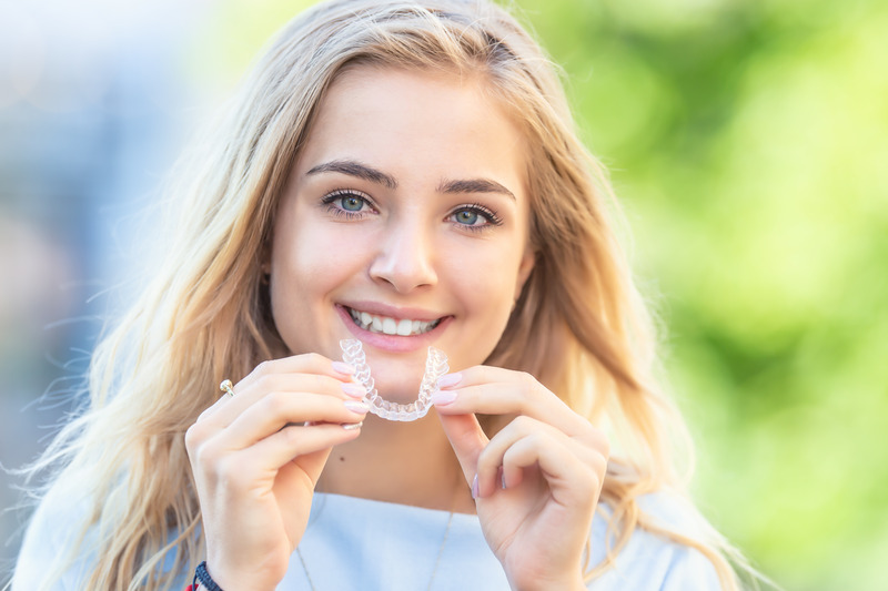 Patient smiling with their Invisalign aligners